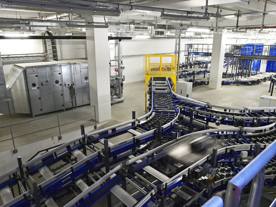 Gepäckförderanlage mit blauen Förderrahmen, Stahlbühne und gelben Schutzgeländern.